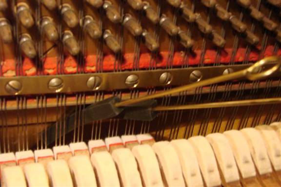 Muting of a three string string-set in the octave (7) below the highest (piano)