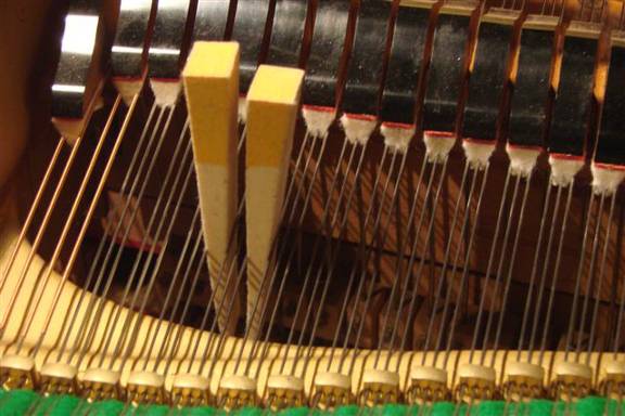 Muting of a three string string-set on a grand piano using two mutes