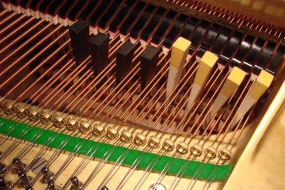 Smorzamento di una serie di gruppi di due corde in un pianoforte a coda mediante l'uso di più cunei