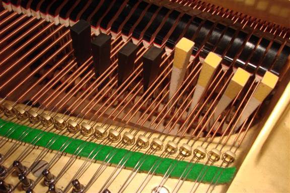 Etouffer une série de bicordes (chœurs) d'un piano à queue à l'aide de plusieurs coins