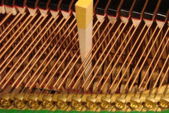 Smorzamento di due gruppi di due corde con un cuneo (pianoforte a coda)